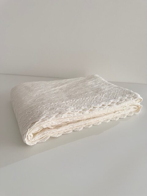 Colcha blanca con volante en el borde