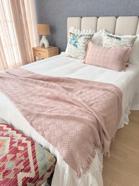 Cama con ropa de cama rosa y blanco