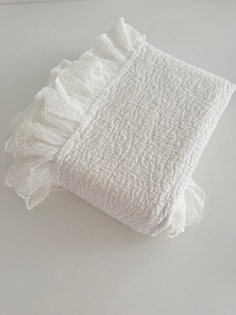 Plaid blanco con flecos doblado