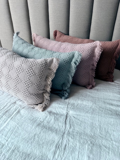 Dormitorio pared azul con cojines rosa y azul